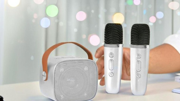 Darček na zábavu v podobe bieleho mini karaoke setu s prenosným reproduktorom a dvoma bezdrôtovými mikrofónmi.