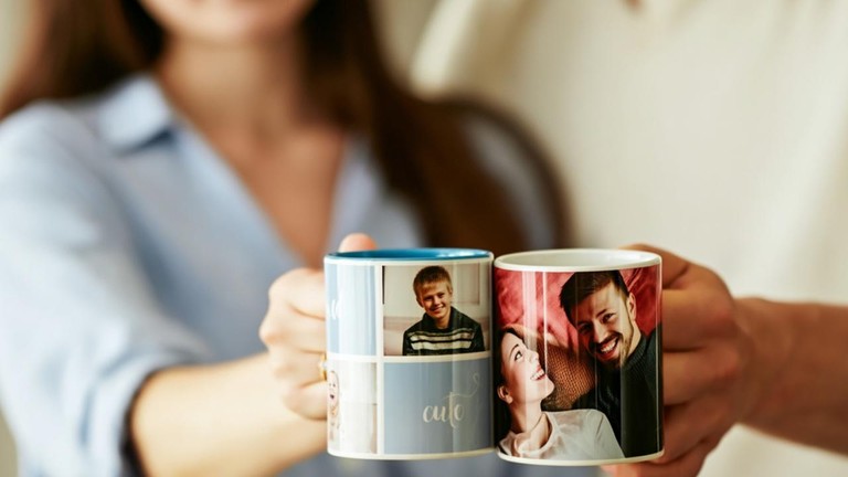 Personalizovaný fotohrnček s vlastnými fotografiami ako originálny darček pre blízkych v rukách dvoch ľudí.